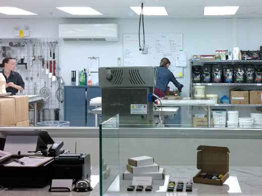 A large window gives curious onlookers a glimpse into the magic, chocolate making process.