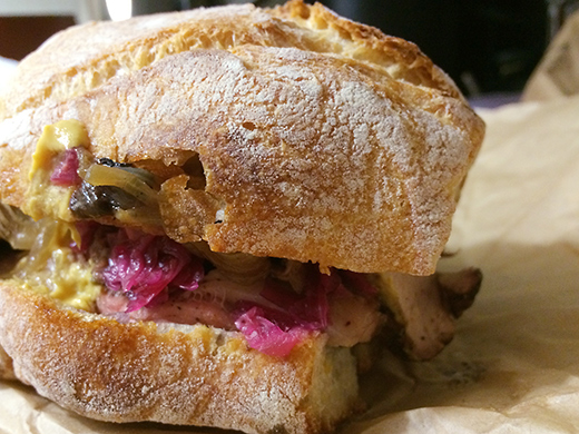 Pork + Cabbage Sandwich ($9) - Grilled pork shoulder, caramelized cabbage, spicy chill oil, mustard sandwiched between a house-baked bread.